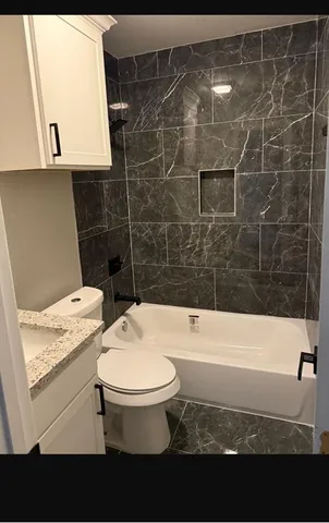 a bathroom with a toilet a sink and bathtub