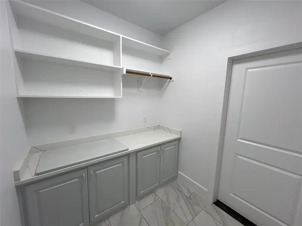 a utility room with cabinets and wooden floor