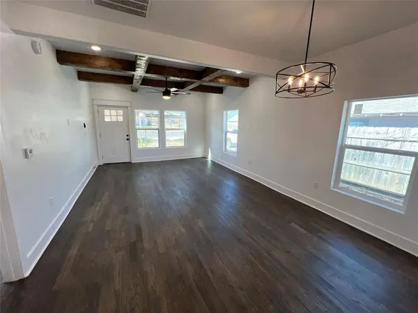 a view of a livingroom with a large window wooden floor and windows