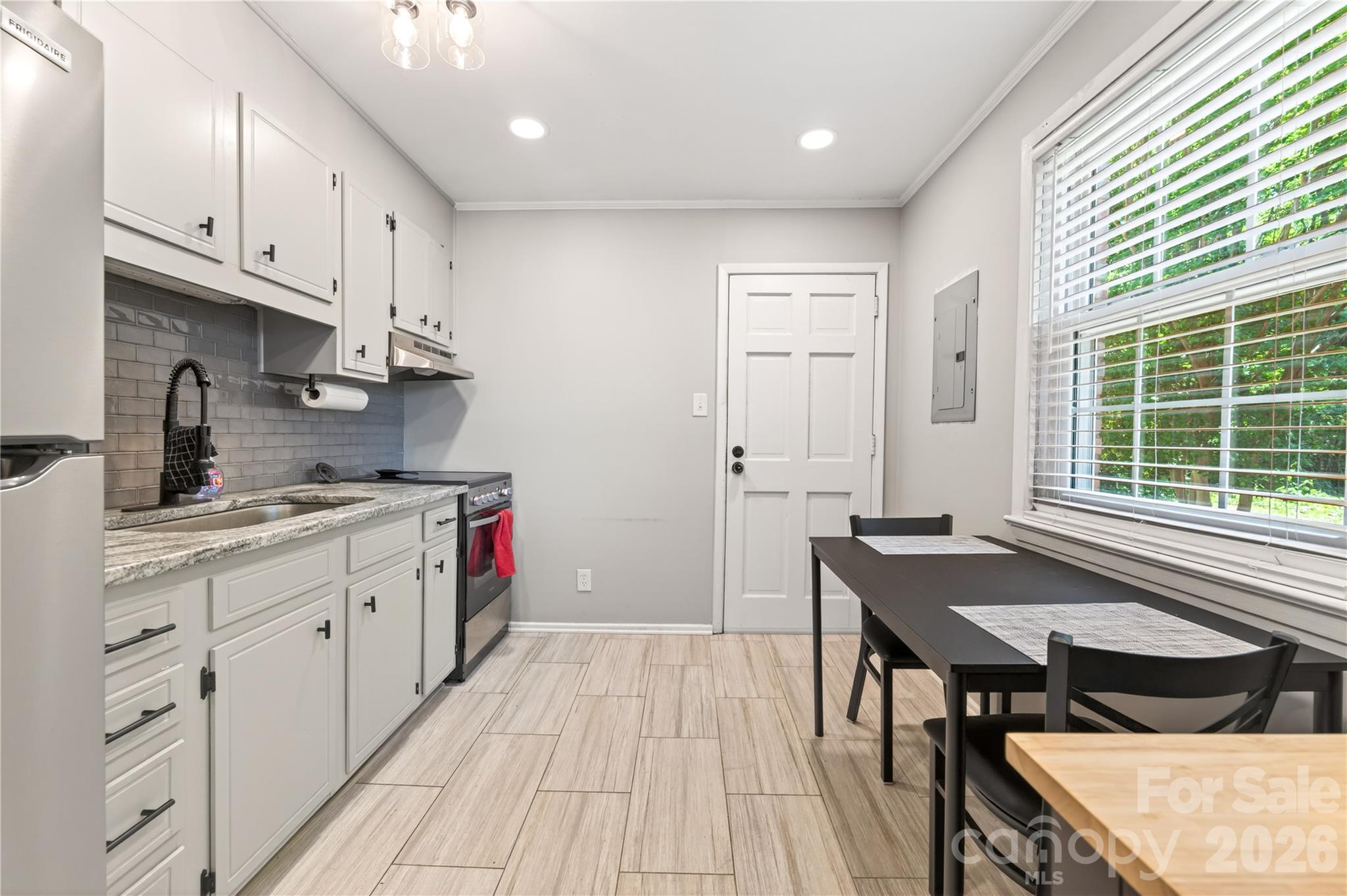 3241 Minnesota Road Charlotte, NC 28208 - Photo 9 of 18 a kitchen with stainless steel appliances granite countertop a stove a sink dishwasher and a refrigerator with wooden floor