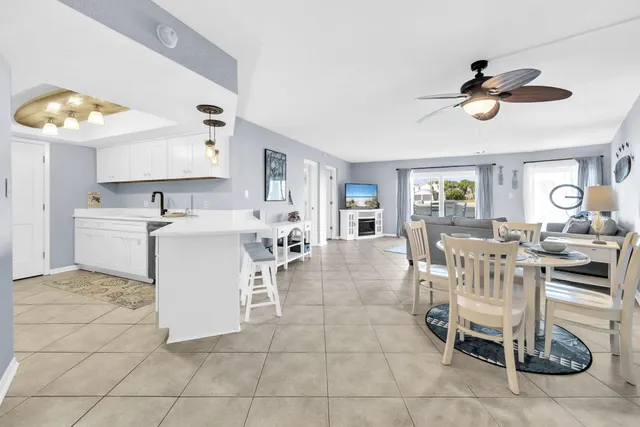 a living room with furniture a rug and wall paintings