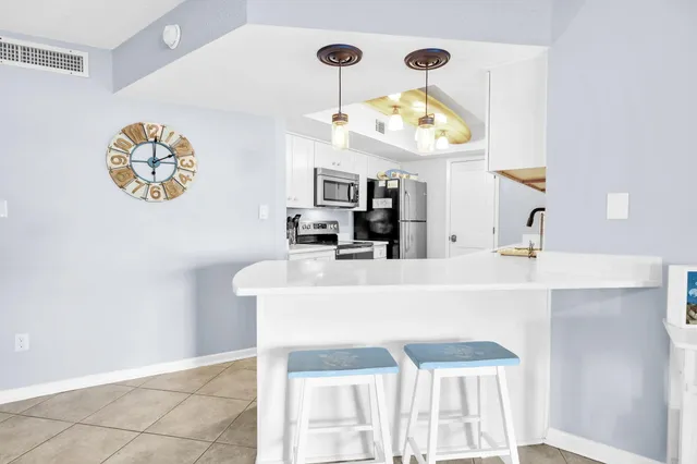 a bedroom with a bed a dresser and painting on the wall
