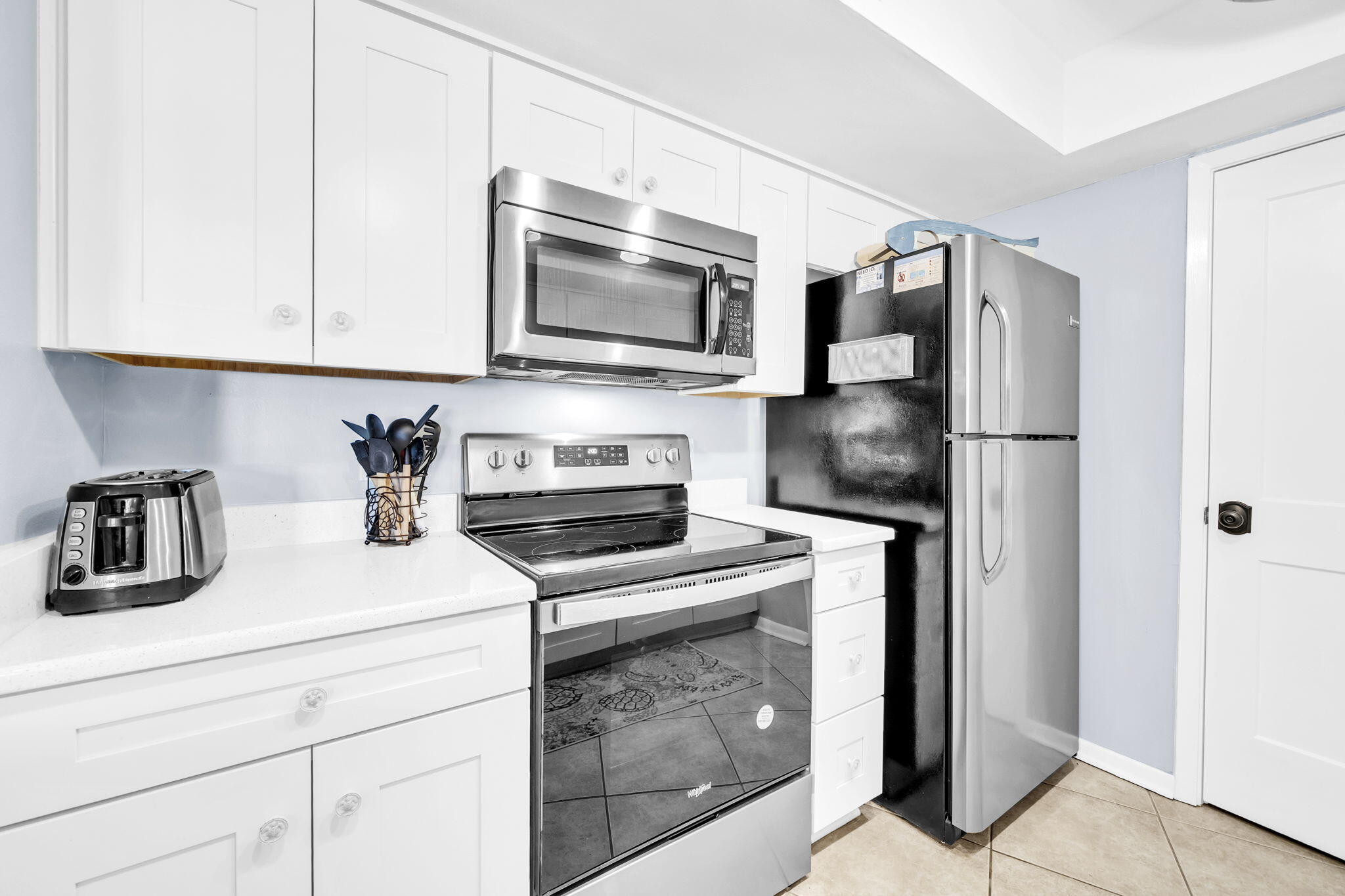 909 Santa Rosa Boulevard, Unit 515 Fort Walton Beach, FL 32548 - Photo 9 of 49 a kitchen with stainless steel appliances granite countertop a refrigerator stove and microwave
