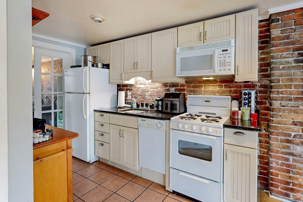 26 Unity Street, Unit 5 Boston, MA 02113 - Photo 5 of 15 a kitchen with stainless steel appliances a stove refrigerator sink and cabinets