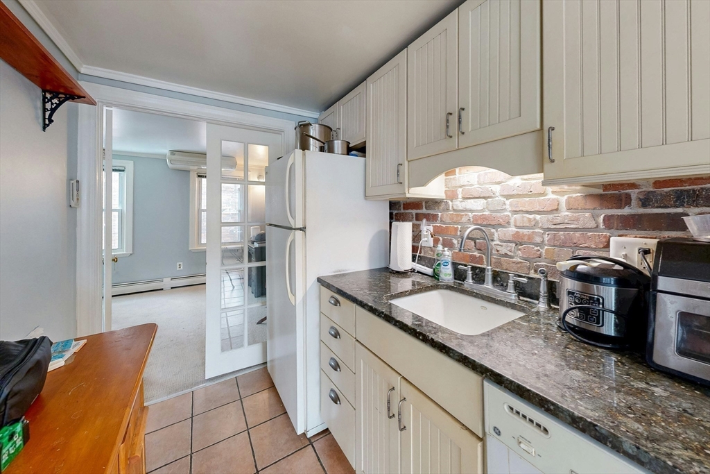 26 Unity Street, Unit 5 Boston, MA 02113 - Photo 6 of 15 a kitchen with granite countertop a refrigerator and a sink