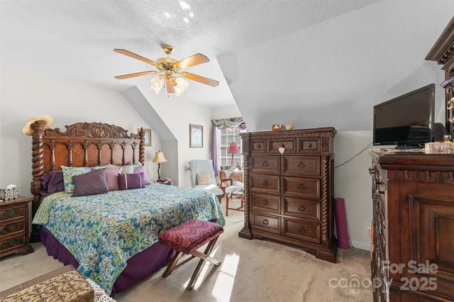 a bedroom with a bed a flat screen tv and dresser