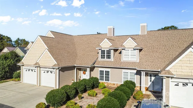 a view of a white house next to a yard