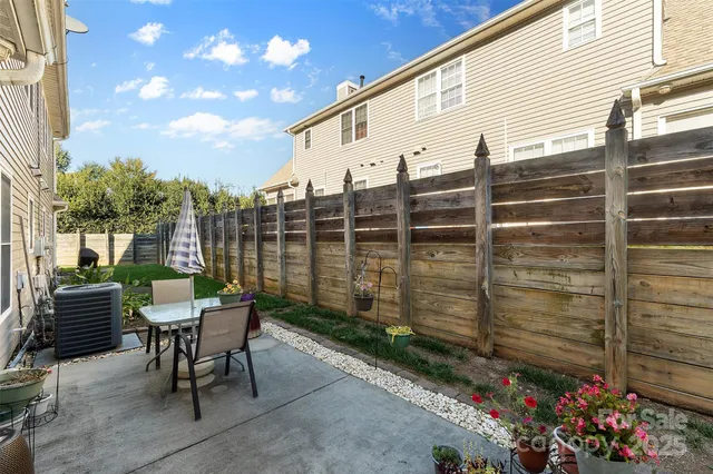a balcony with table and chairs and potted plants