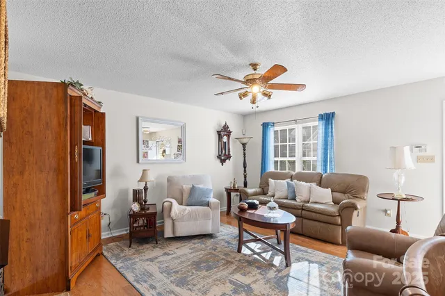 a living room with furniture wooden floor and a large window