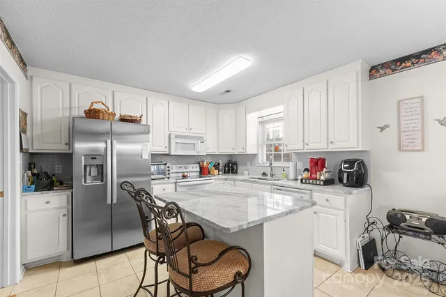 a kitchen with a sink a refrigerator and cabinets