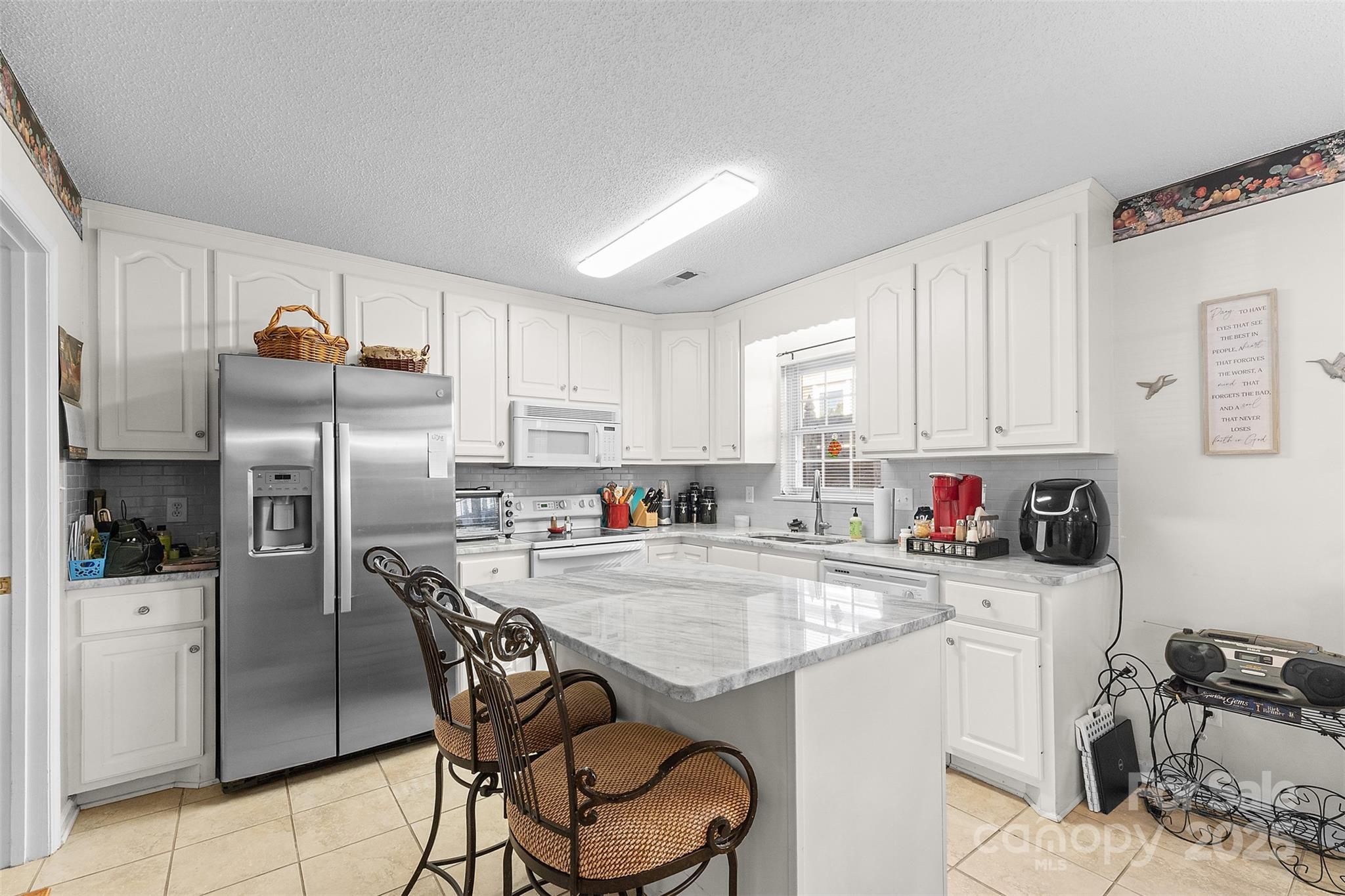 1553 16th Avenue Northeast, Unit 7 Hickory, NC 28601 - Photo 8 of 32 a kitchen with a sink a refrigerator and cabinets