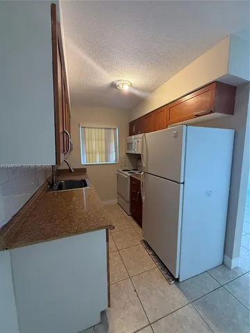 a kitchen with a refrigerator and a sink