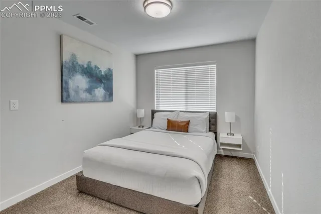 a bedroom with a bed and a painting on the wall