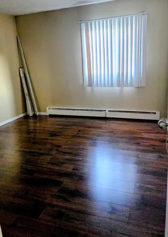 a room with wooden floor and a window
