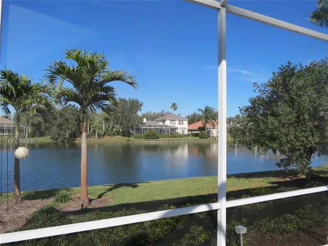 a living room with patio furniture and floor to ceiling window