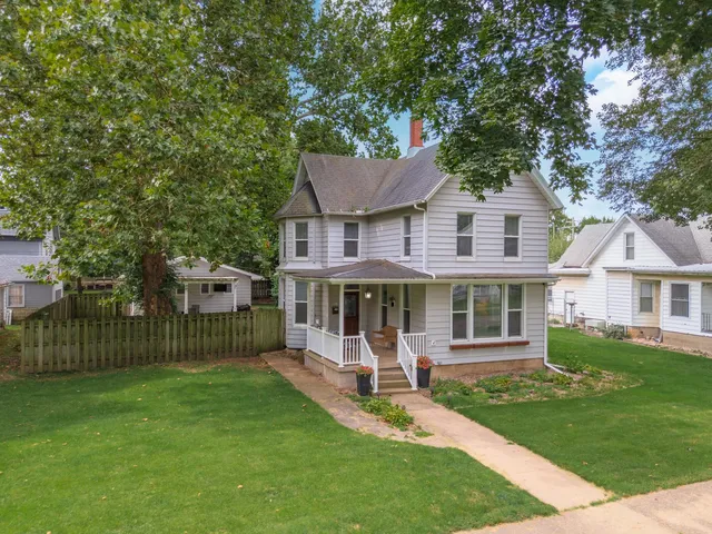 a front view of a house with a garden and yard