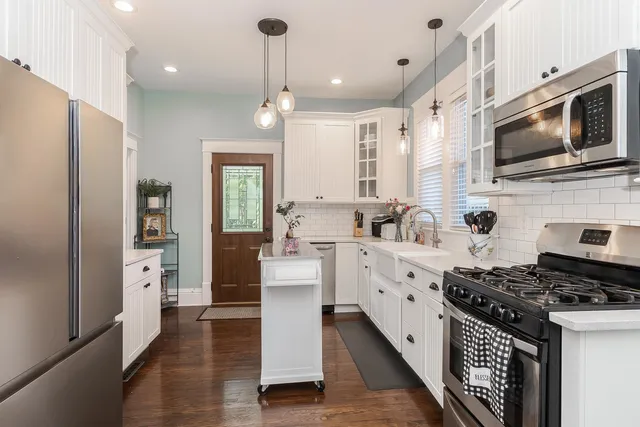 a kitchen with stainless steel appliances a stove a sink and a refrigerator