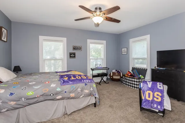 a bedroom with a bed a couch and a window