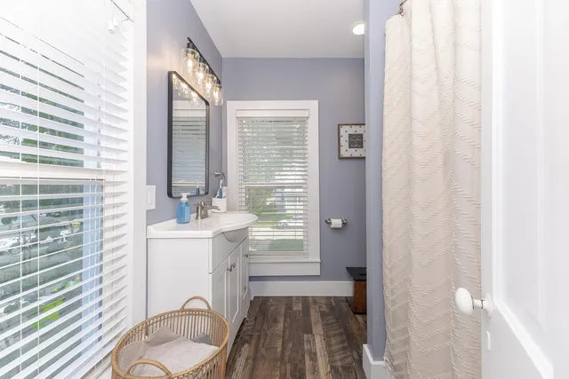a spacious bathroom with a sink a mirror a bathtub and next to a window