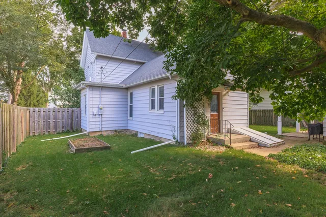 a backyard of a house with table and chairs