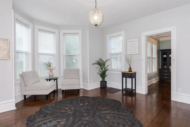 a living room with furniture wooden floor and a table