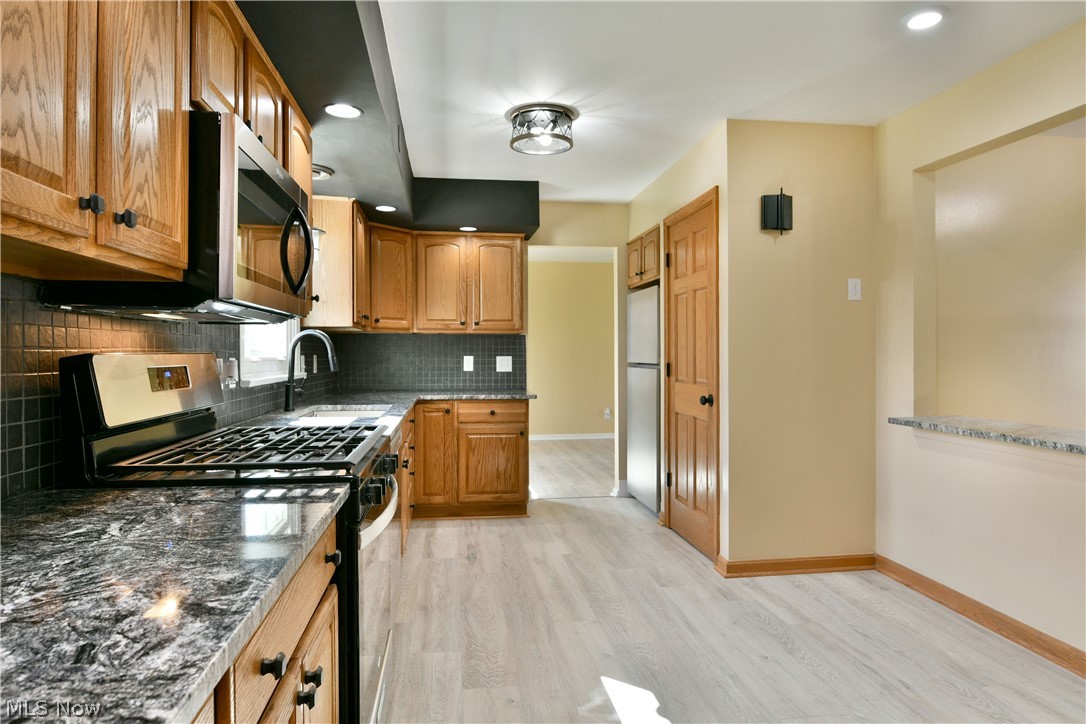 105 Fairview Avenue Cortland, OH 44410 - Photo 16 of 47 Kitchen with stainless steel appliances, dark stone counters, light wood-style flooring, recessed lighting, and wood finish cabinetry