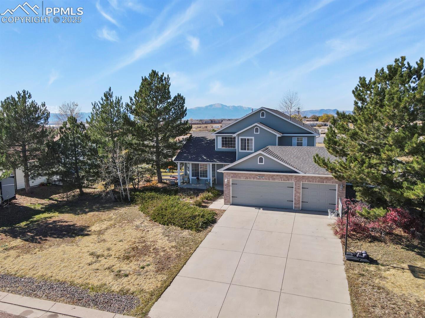 7660 Bullet Road Peyton, CO 80831 - Photo 43 of 50 Traditional-style house with driveway, a garage, brick siding, and a mountain view
