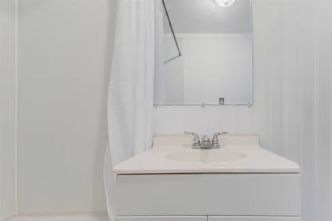 a white toilet sitting next to a bathroom sink and vanity