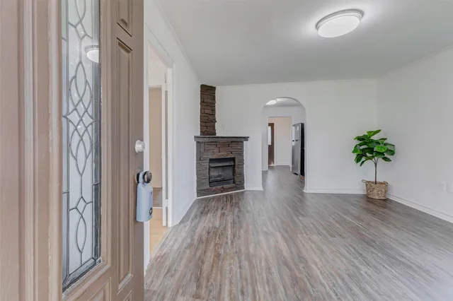 a view of a hallway with wooden floor and a fireplace