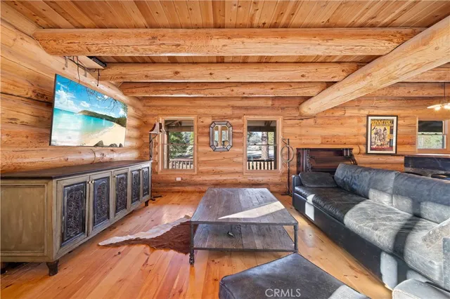 a living room with furniture a flat screen tv and a floor to ceiling window