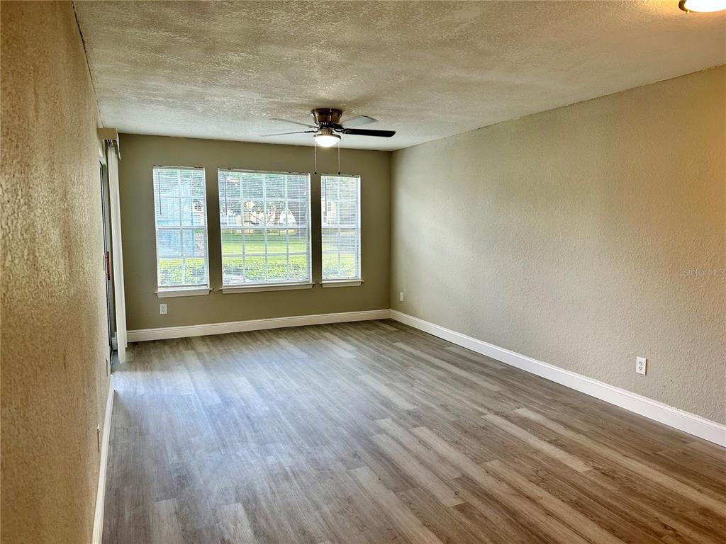 1025 South Hiawassee Road, Unit 2214 Orlando, FL 32835 - Photo 3 of 26 a view of an empty room with wooden floor and a window