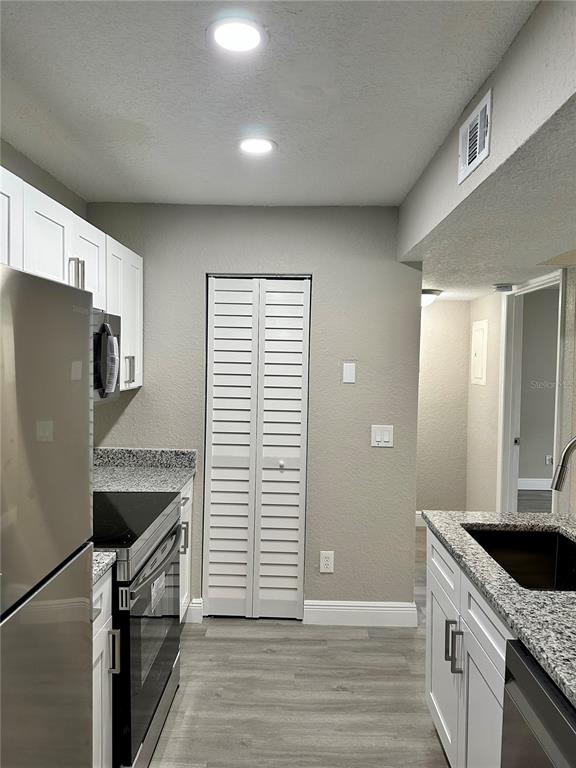 1025 South Hiawassee Road, Unit 2214 Orlando, FL 32835 - Photo 4 of 26 a kitchen with granite countertop a sink stove and refrigerator
