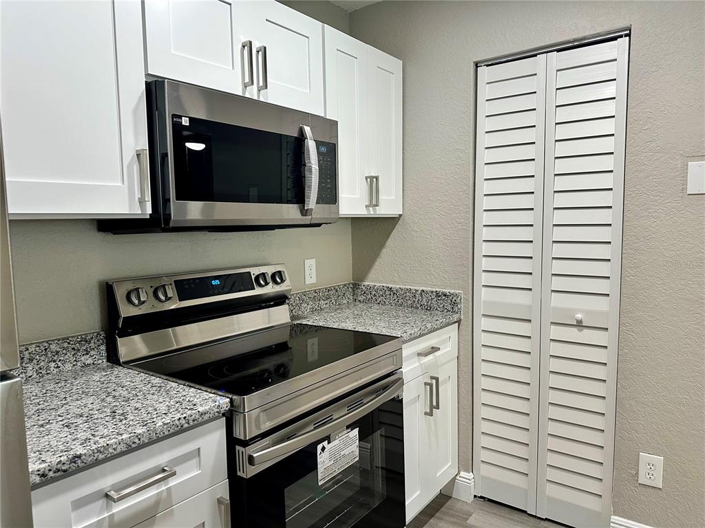 1025 South Hiawassee Road, Unit 2214 Orlando, FL 32835 - Photo 5 of 26 a kitchen with a stove and a microwave