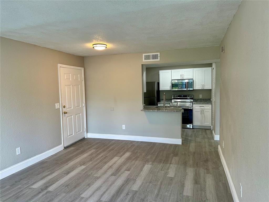 1025 South Hiawassee Road, Unit 2214 Orlando, FL 32835 - Photo 6 of 26 a view of a kitchen with a sink stove cabinets and empty room