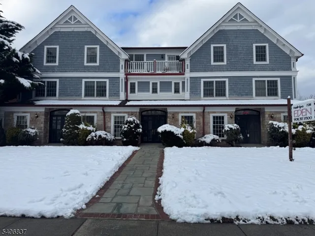 a front view of a house with a yard covered in snow