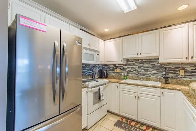 a kitchen with stainless steel appliances granite countertop a refrigerator and a sink