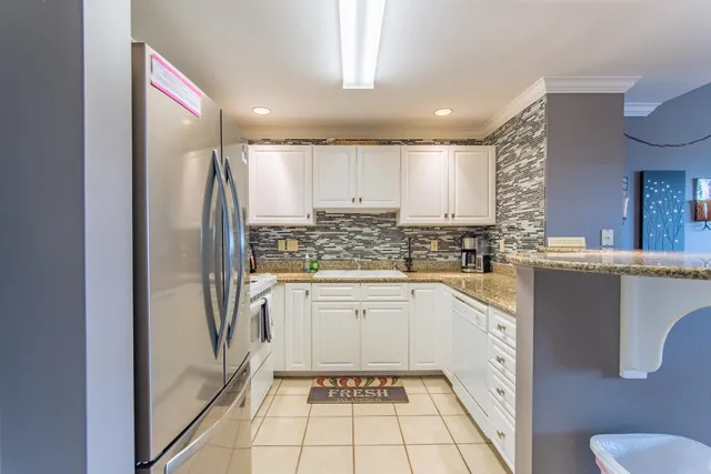 a kitchen with granite countertop white cabinets and white appliances