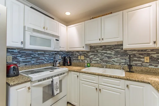 a kitchen with stainless steel appliances granite countertop a sink stove and cabinets