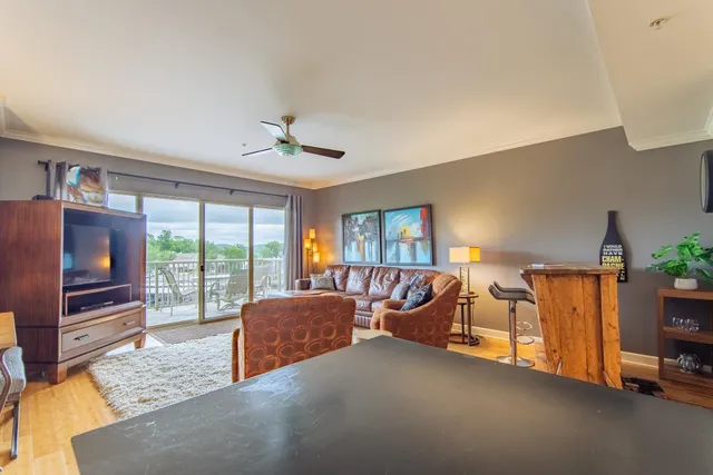 a living room with furniture a flat screen tv and a large window