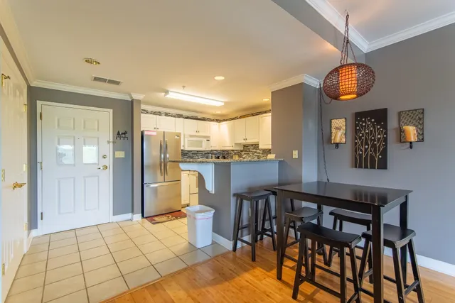 a kitchen with white cabinets white stainless steel appliances and refrigerator