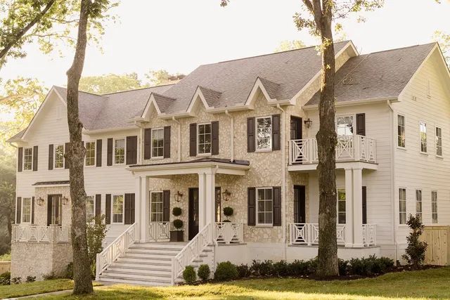 a view of a white house with a yard and plants