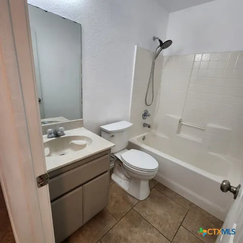 a view of an empty room with a ceiling fan a ceiling fan and wooden floor
