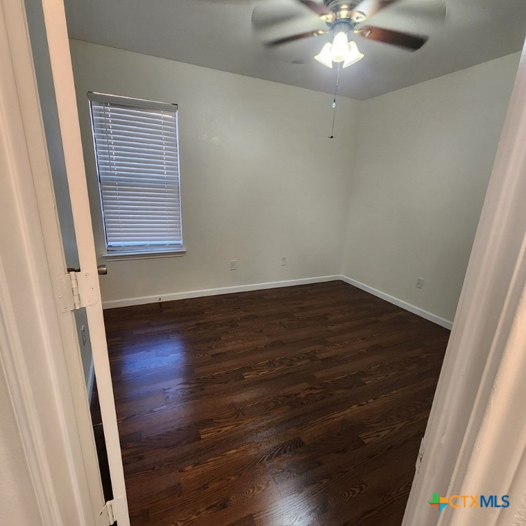 1111 Travis Circle Copperas Cove, TX 76522 - Photo 19 of 24 en empty room with wooden floor and fan