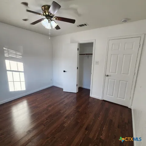 a view of a small space with wooden floor and a window