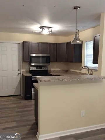 a kitchen with kitchen island a counter top a refrigerator and a sink