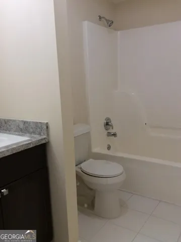 a bathroom with a granite countertop toilet and a sink