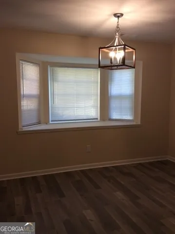 a view of wooden floor chandelier and window in a room