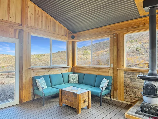 a very nice looking living room with a large window wooden floor and furniture