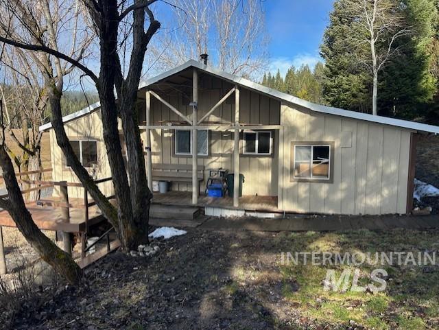 Entry view of house with a wooden deck and board and batten siding
