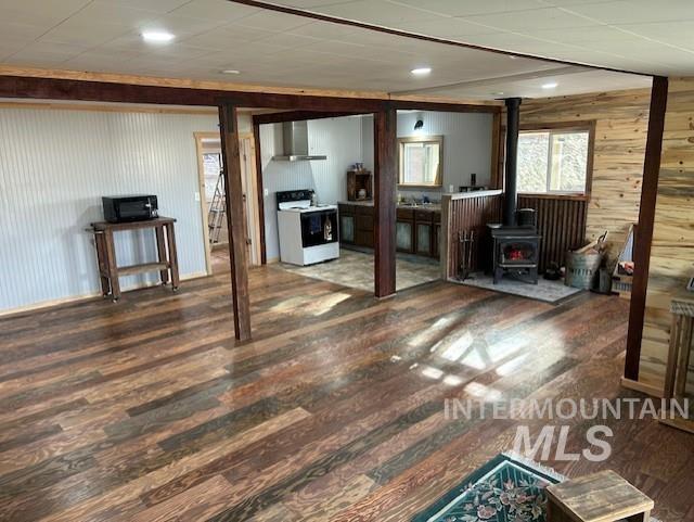 820 Sweeney Road Elk City, ID 83525 - Photo 13 of 45 Living area with a wood stove, wooden walls, and dark wood-style flooring